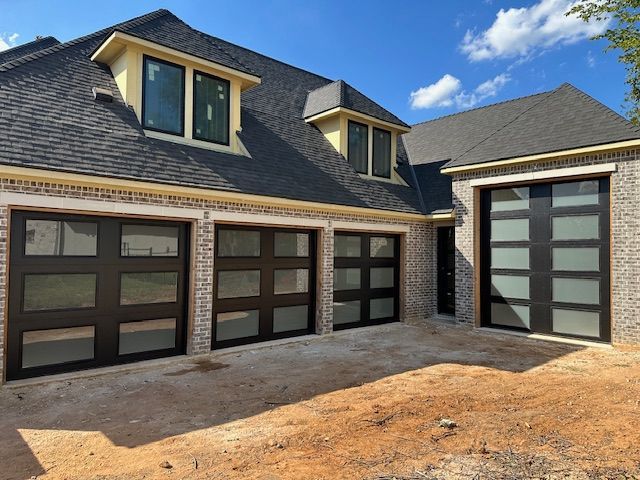 A house with a lot of windows and a lot of garage doors.