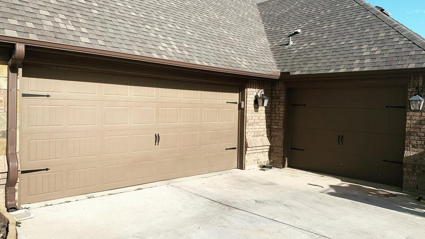 There are two garage doors on the side of a house.