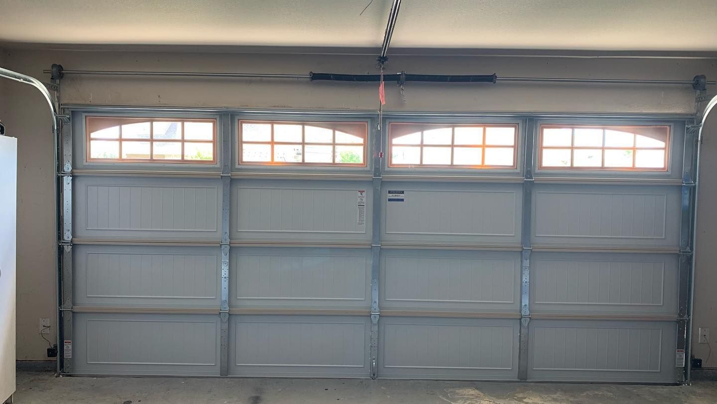 A garage door with a lot of windows and a garage door opener.