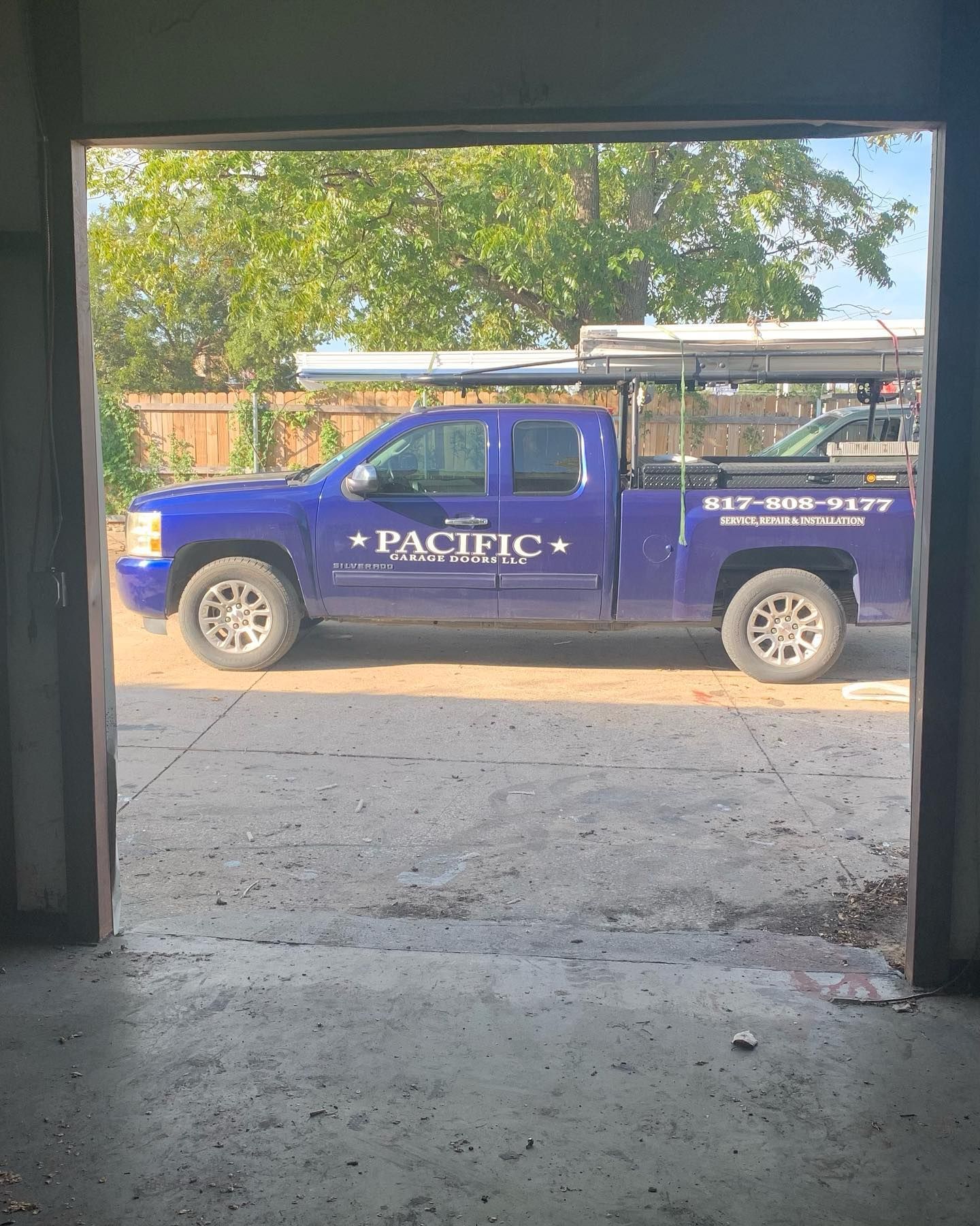 A blue pacific truck is parked in a garage