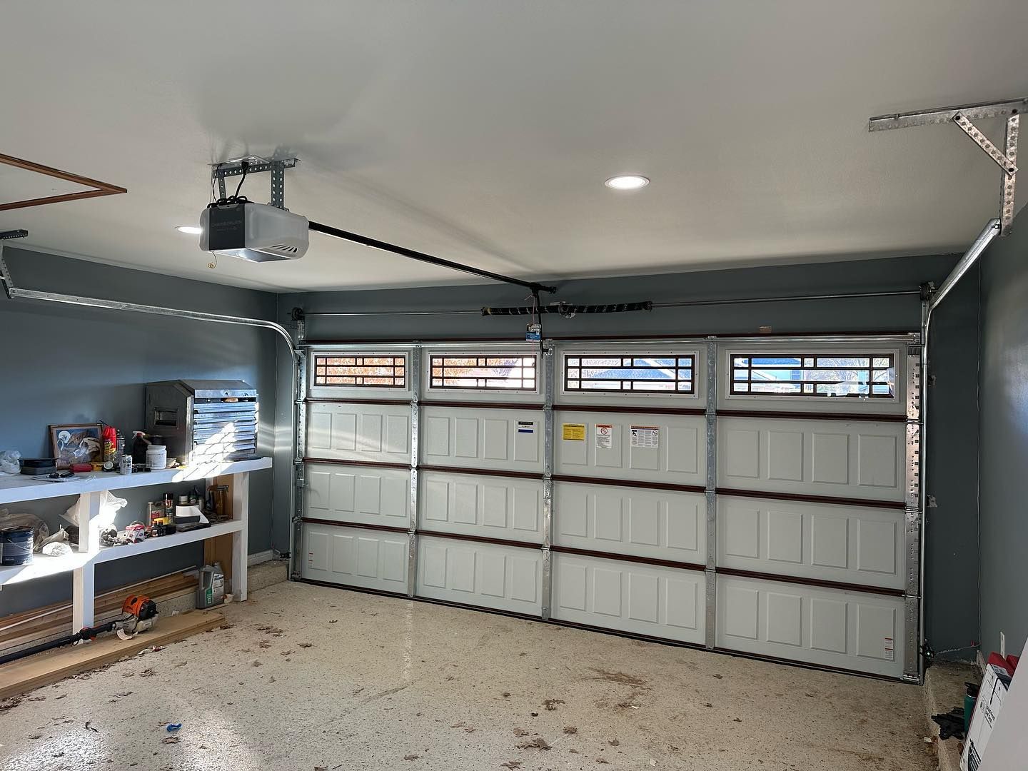 A garage with a garage door open and a garage door opener.