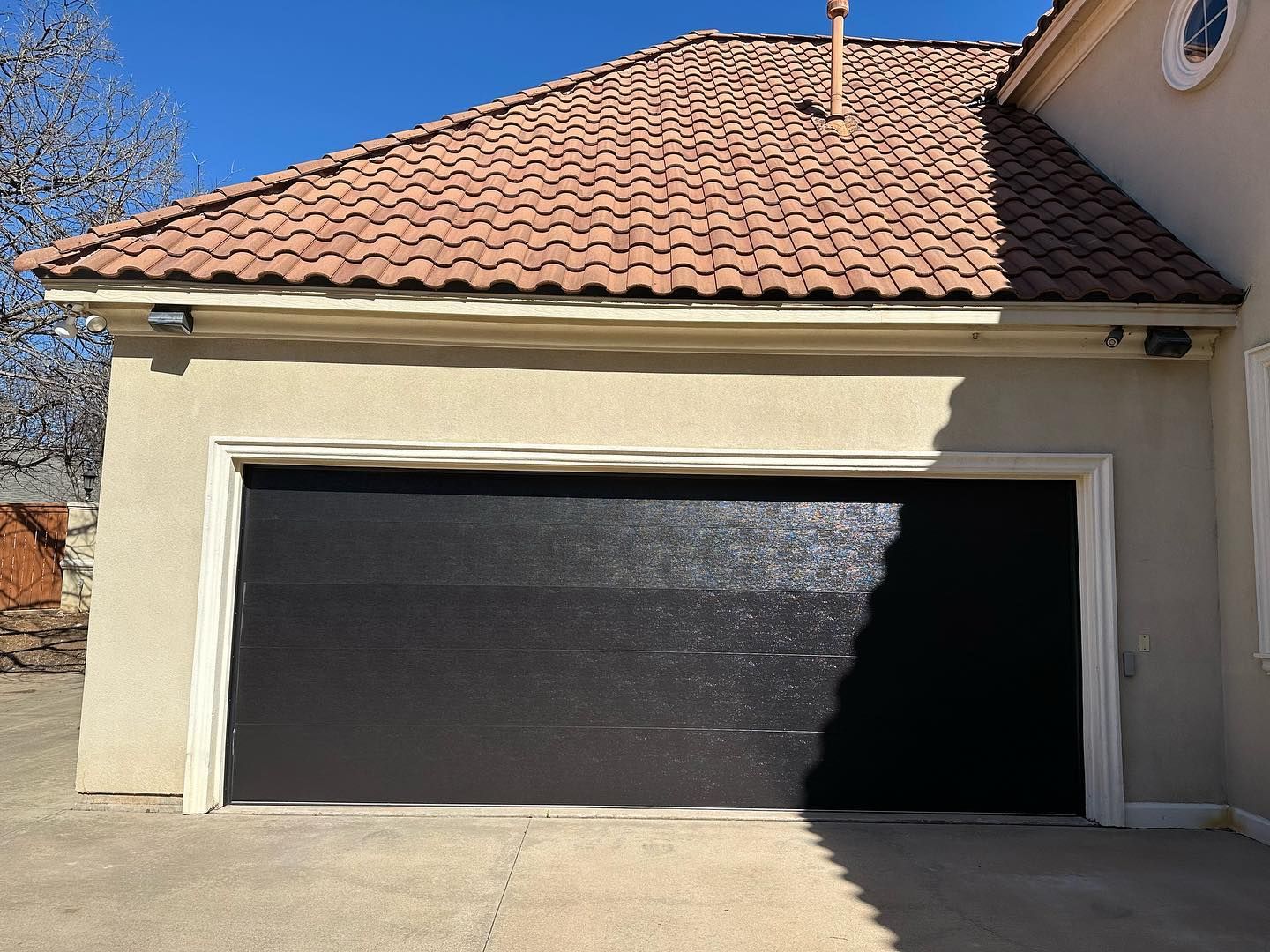 A house with a black garage door and a tiled roof