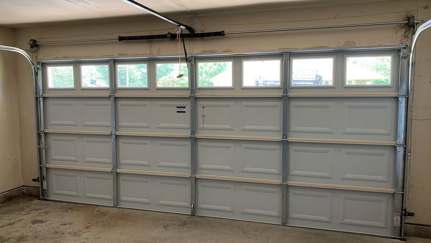 A white garage door is open in a garage.