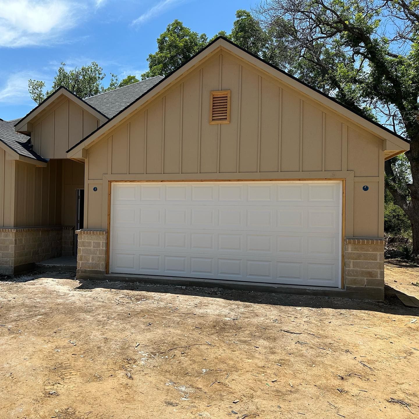 A house with a large white garage door and a sign that says ' a ' on it