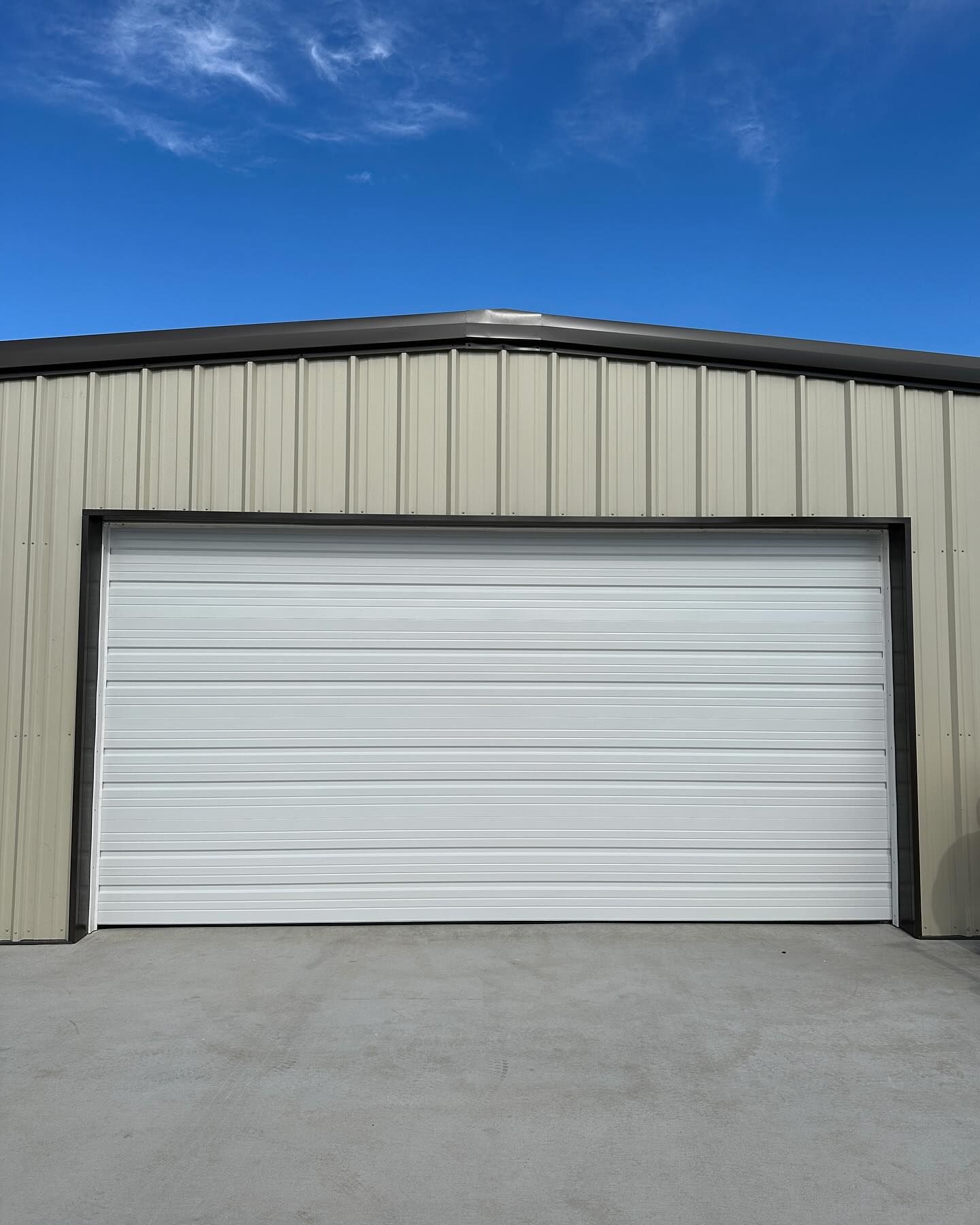 A white garage door with a blue sky in the background