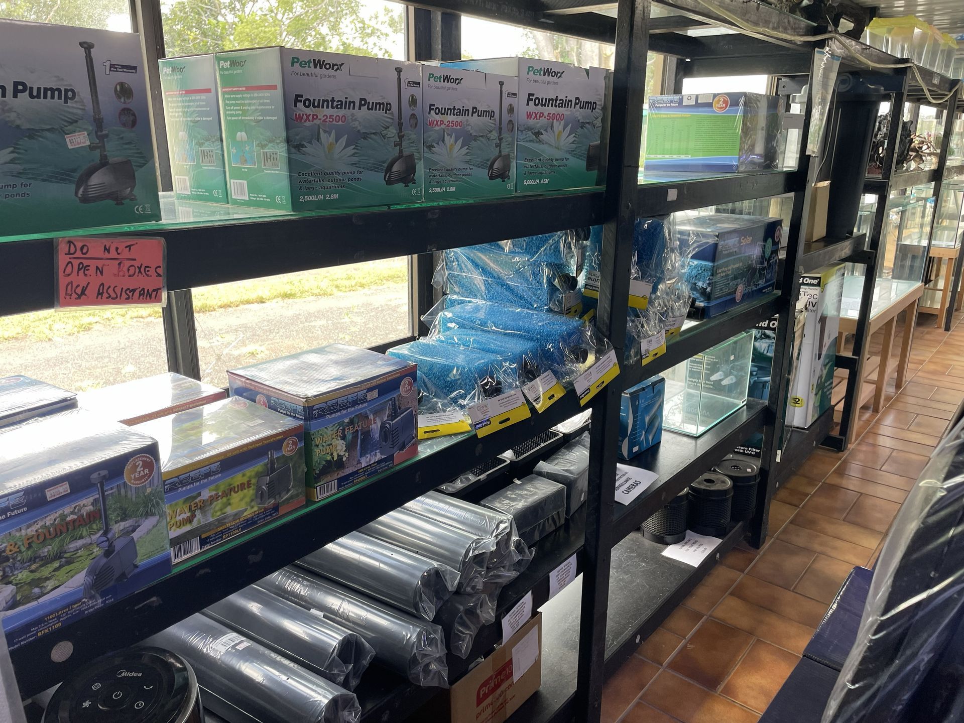 Shelves stocked with aquarium supplies in a store. Several boxes of water pumps and filters are visible.