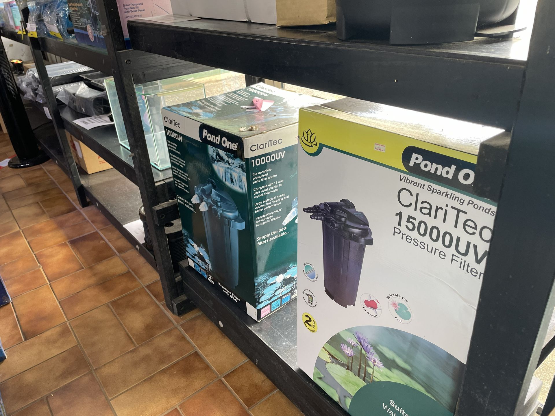 Boxes of pond filters on a shelf in a store, including a box labeled 
