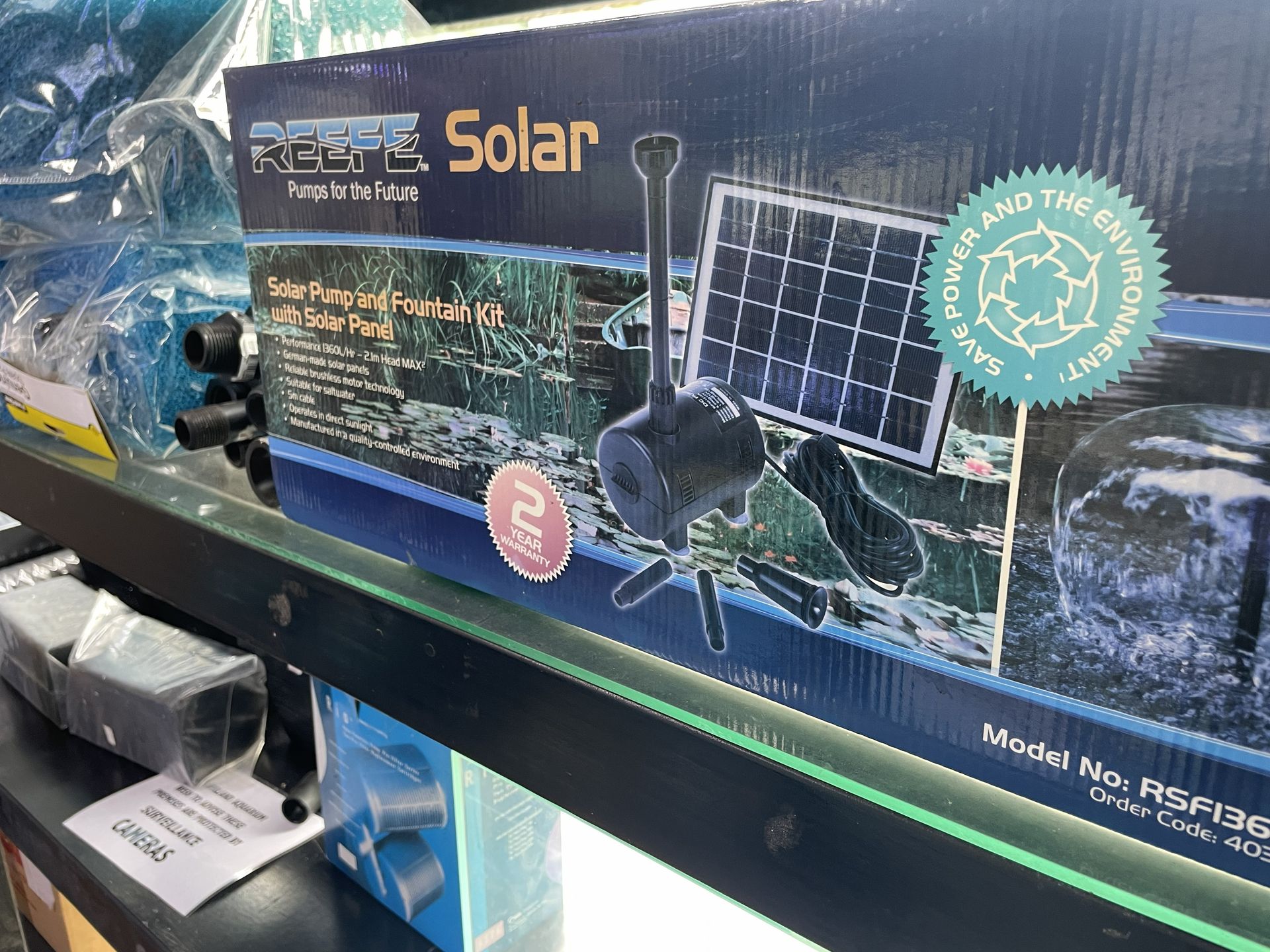 Boxed solar fountain pump on a shelf.