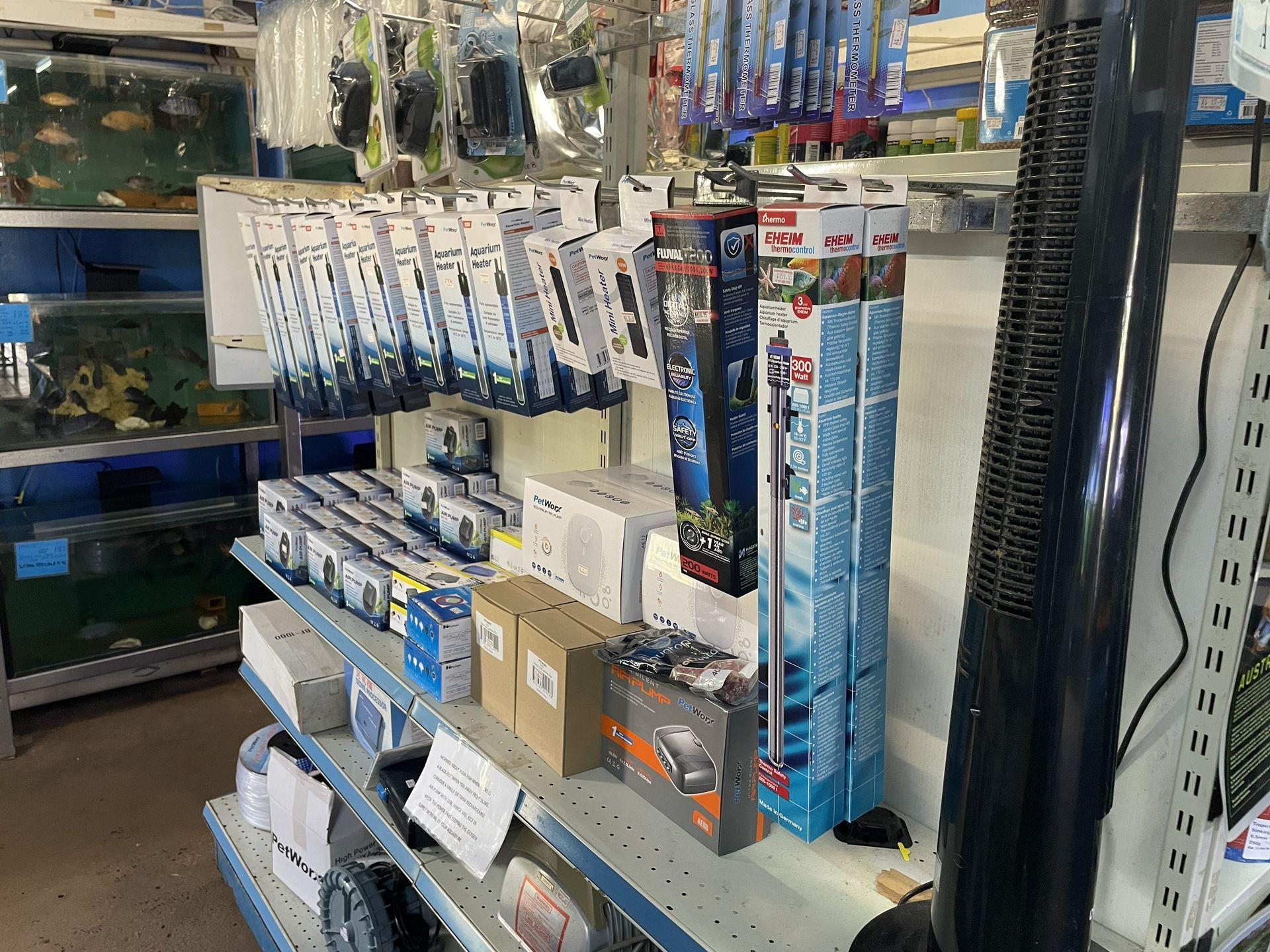 Shelves in a pet store stocked with aquarium supplies, including heaters, filters, and other equipment.