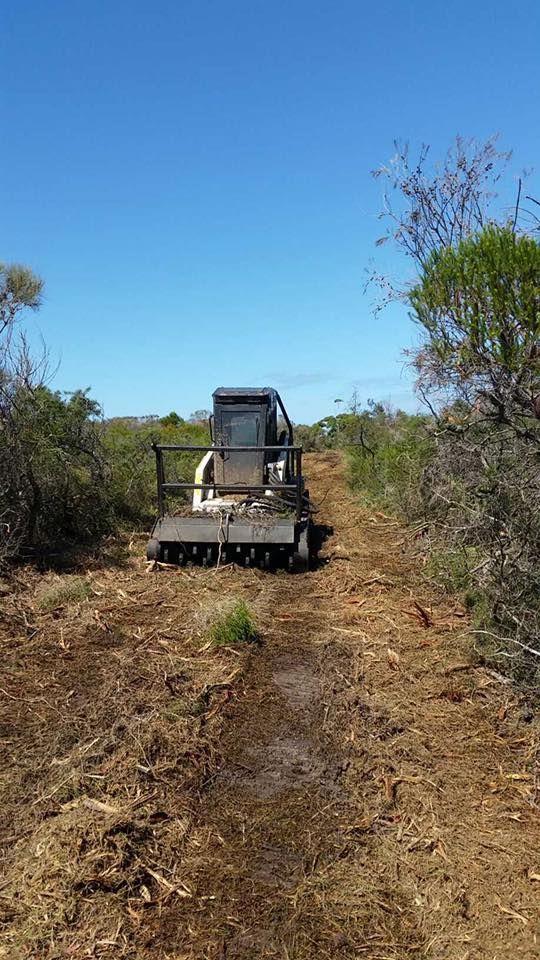 A bulldozer is driving down a dirt road.
