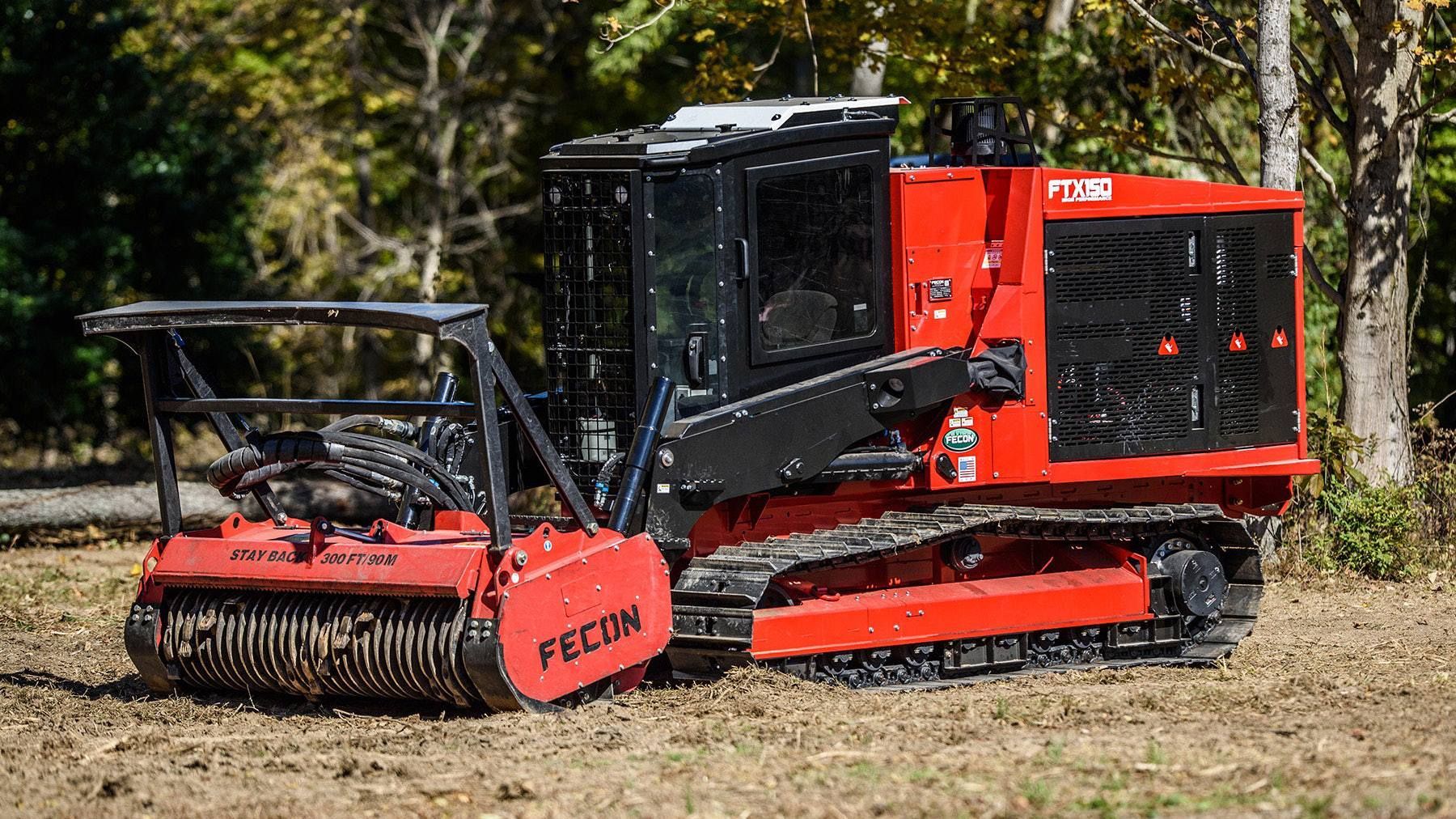 A red and black tractor is sitting in a field.