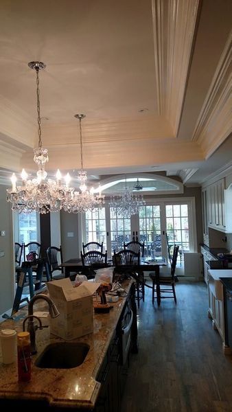 Kitchen with a chandelier over a dining table, leading to a patio.