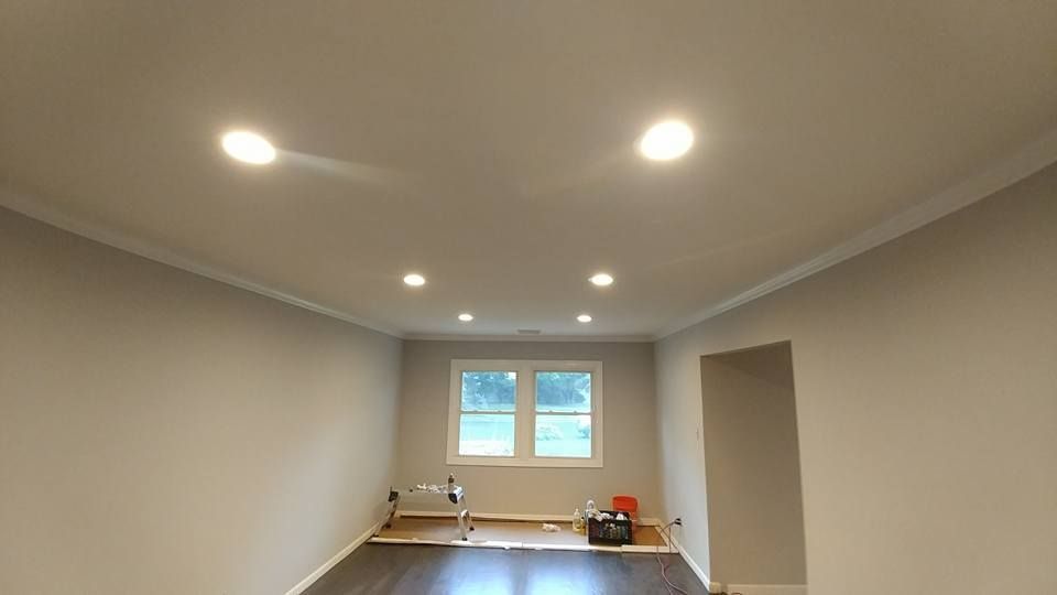 A room with recessed lights, crown molding, neutral walls, dark floor, and a window.
