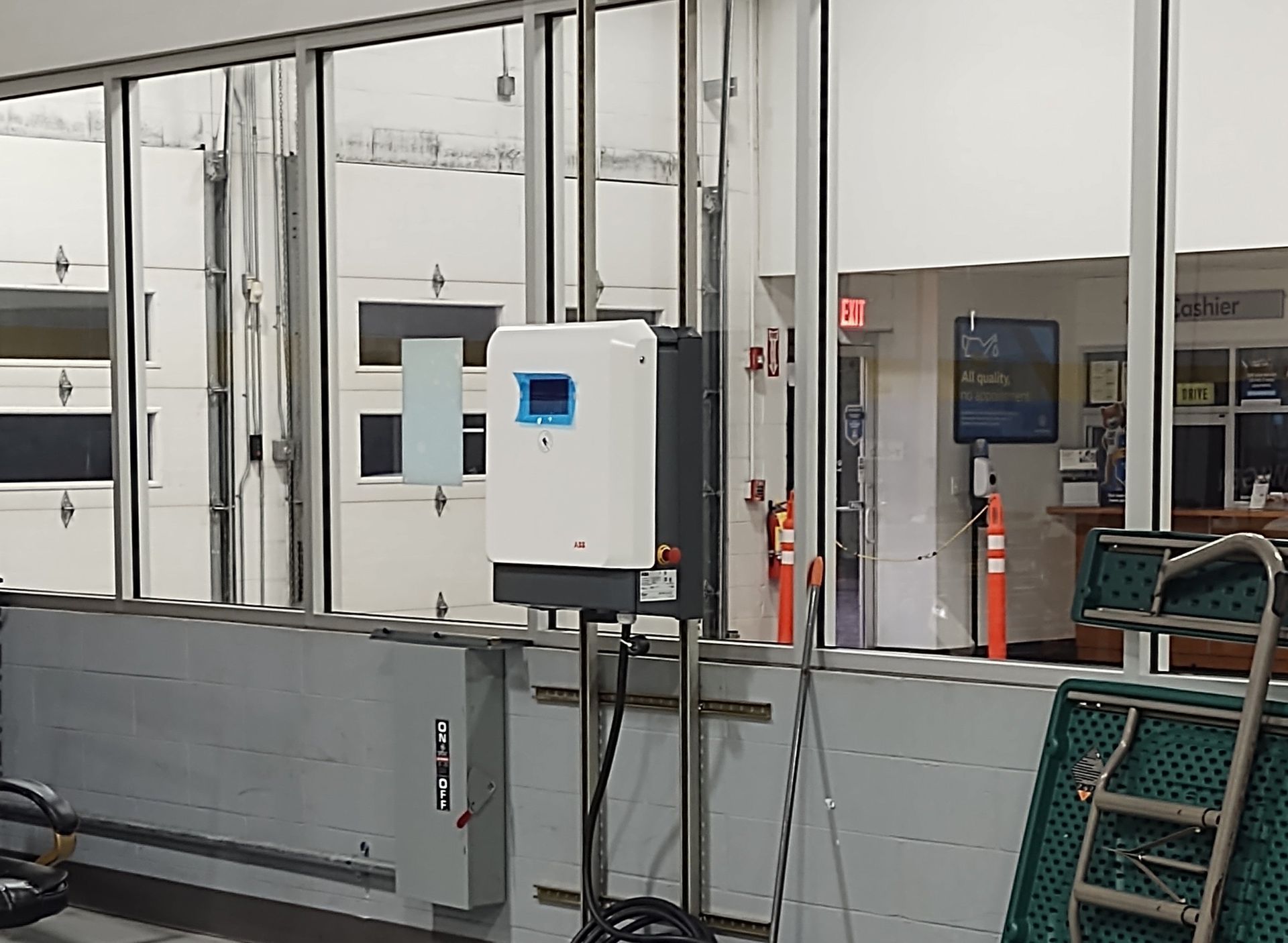 White and gray solar power inverter box mounted on a wall, interior shop setting.