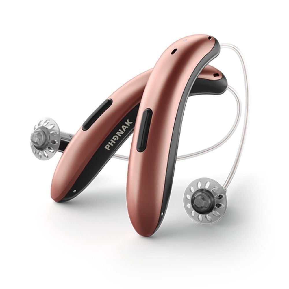 Two metallic rose gold Phonak hearing aids with clear receiver tubes and domes displayed against a white background.