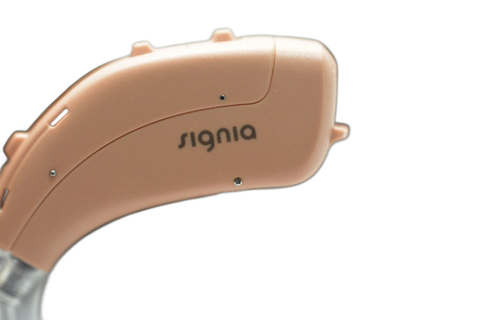 A close-up side view of a beige Signia behind-the-ear hearing aid on a white background.