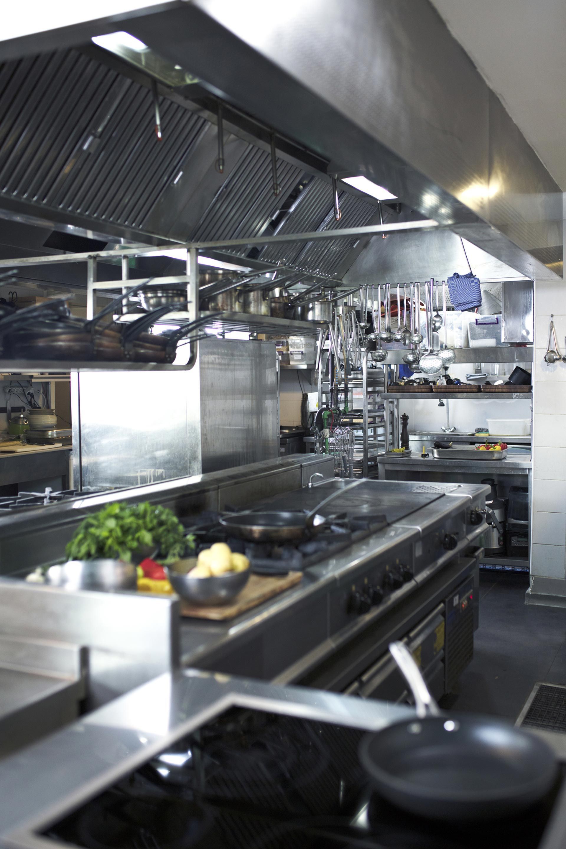 A kitchen with a lot of pots and pans on the stove