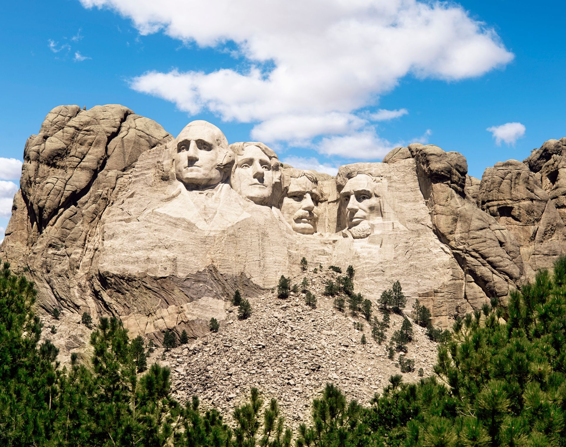 The presidents ' faces are carved into the side of a mountain.