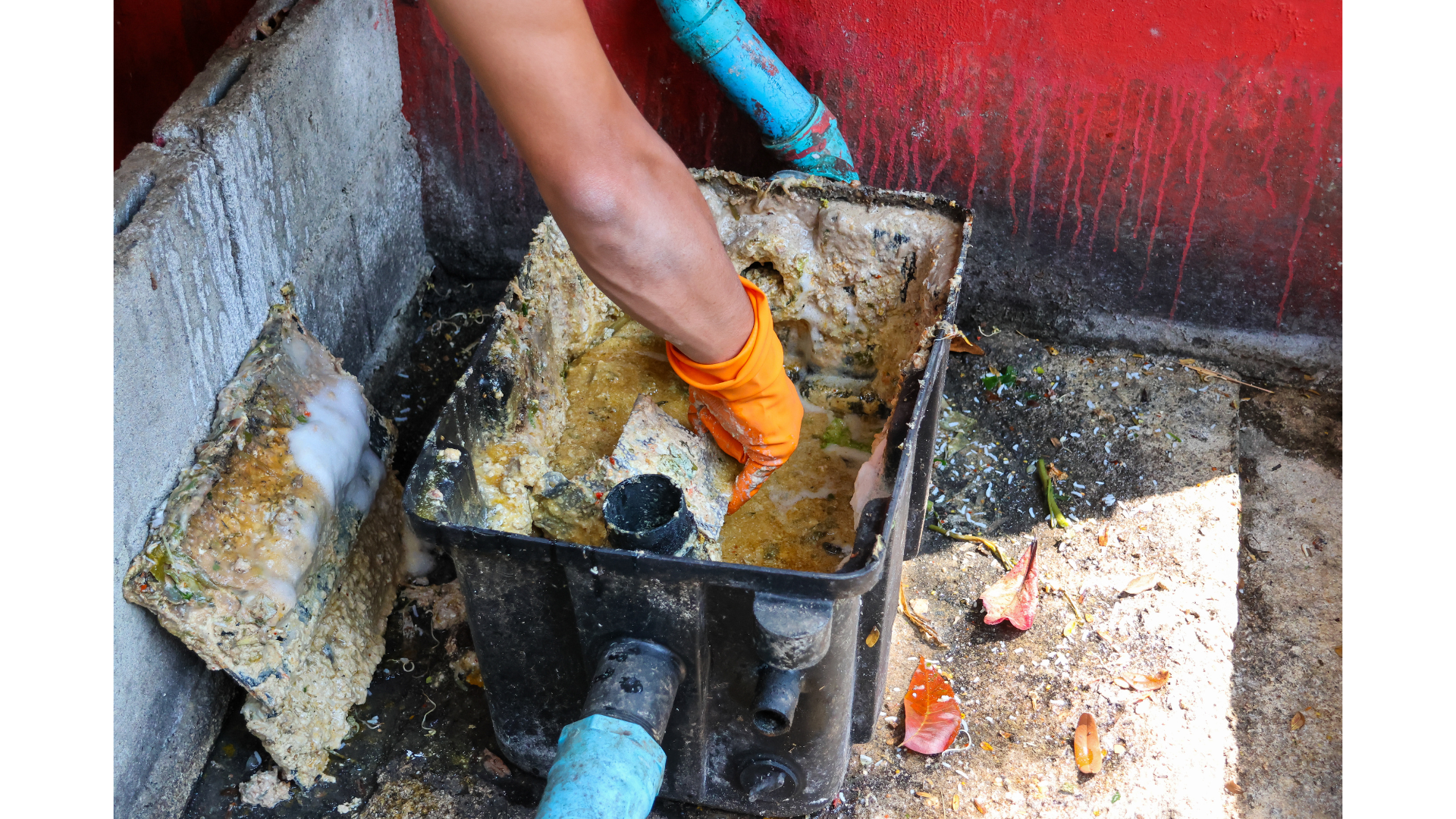 A person is cleaning a dirty drain with a hose.