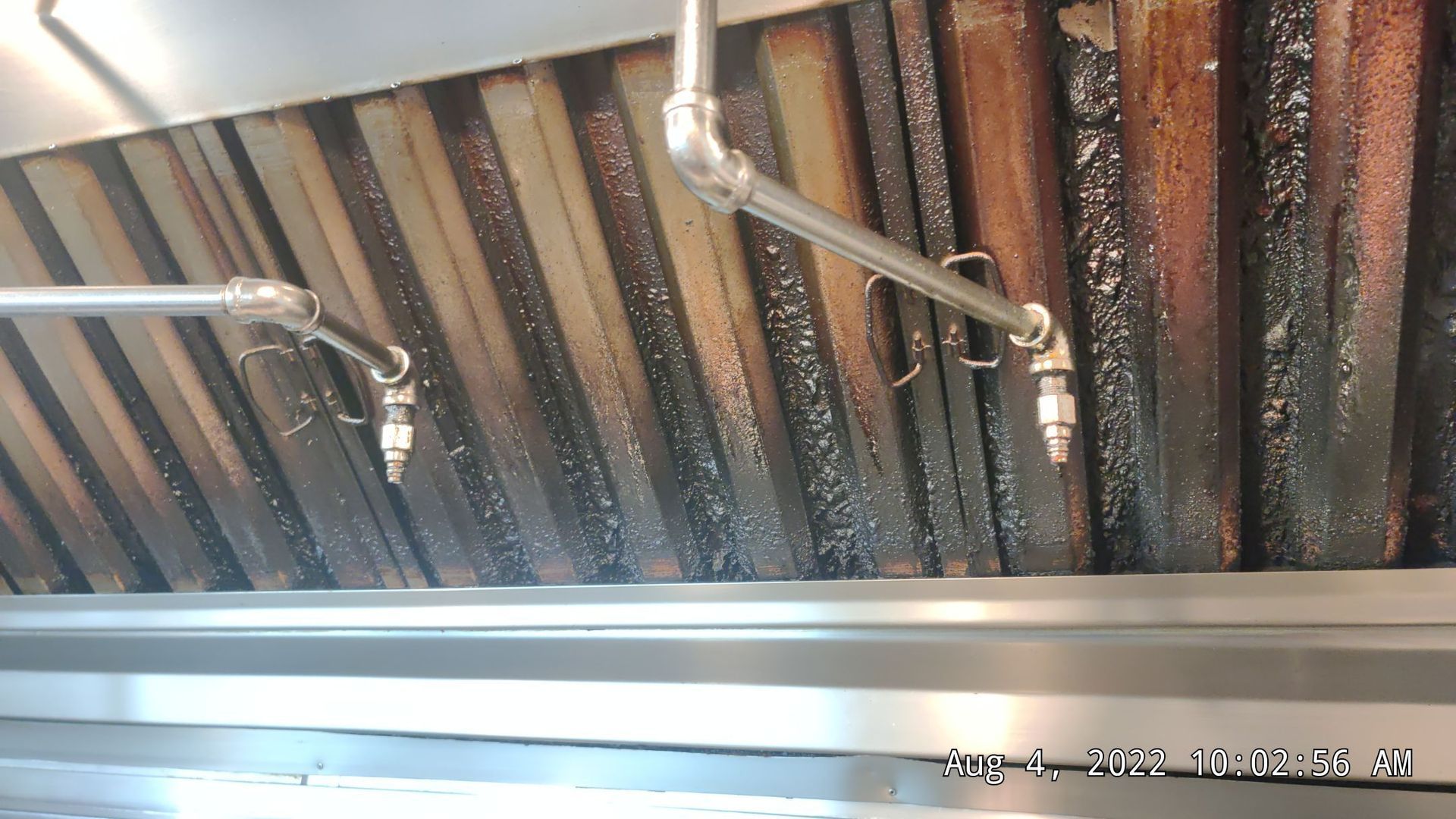 A close up of a ceiling with pipes hanging from it.