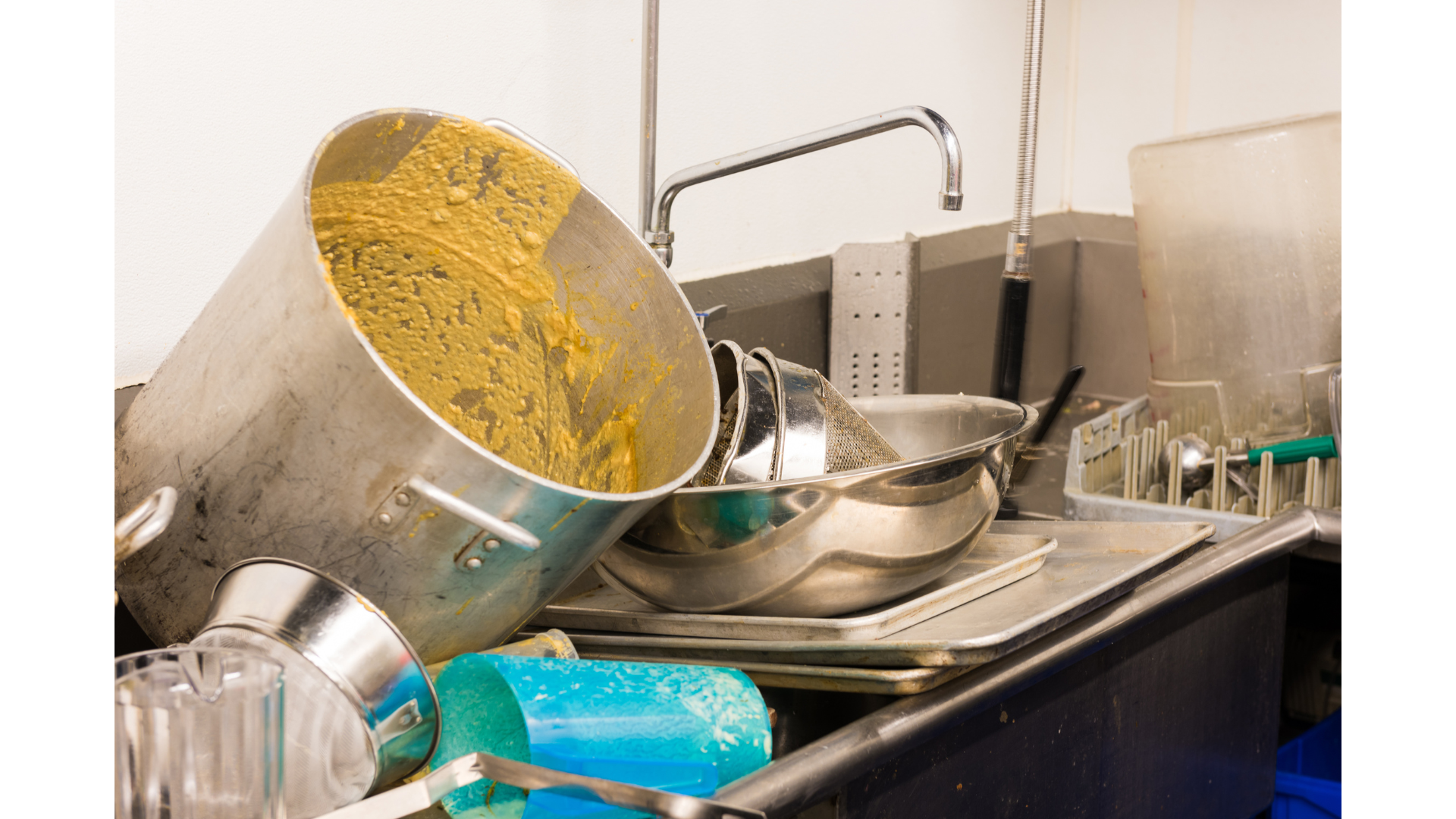 A kitchen sink filled with dirty dishes and pots and pans.