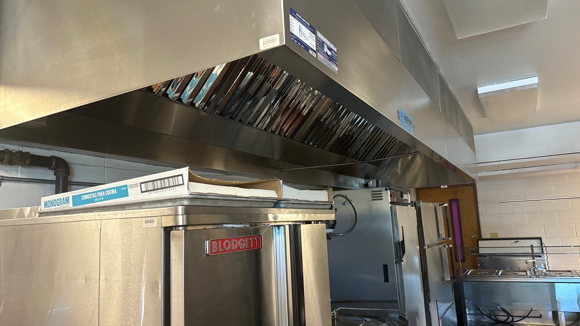 Modern stainless steel kitchen range hood with built-in lights and ventilation system. Modern stainless steel kitchen range hood with built-in lights and ventilation system.