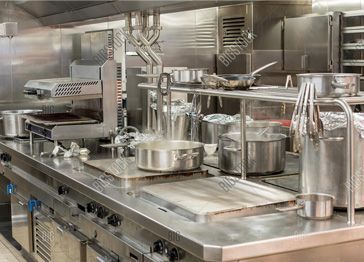 A large commercial kitchen with stainless steel appliances and pots and pans.