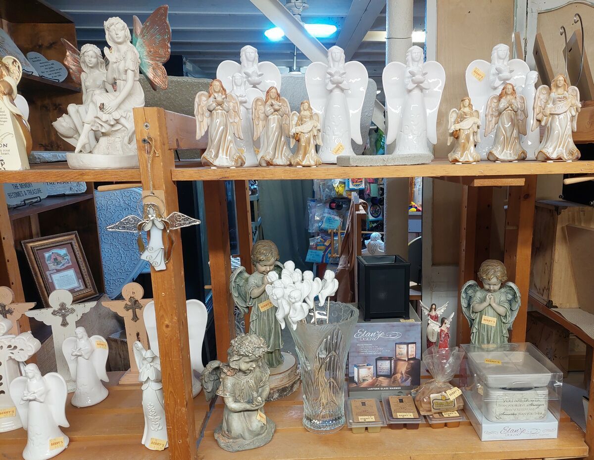 A shelf filled with lots of statues of angels