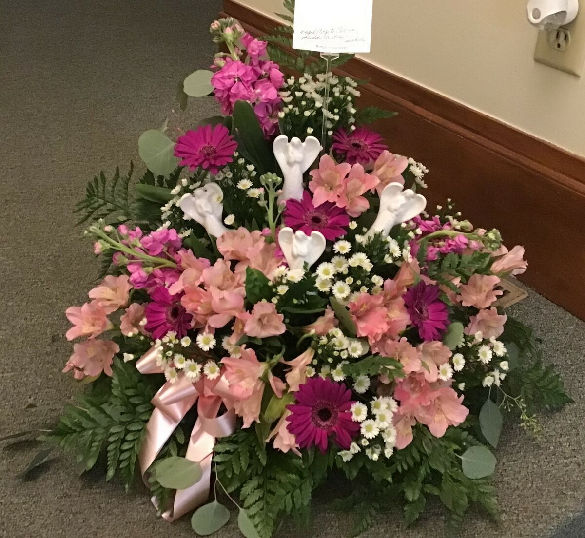 A bouquet of pink and white flowers is sitting on the floor