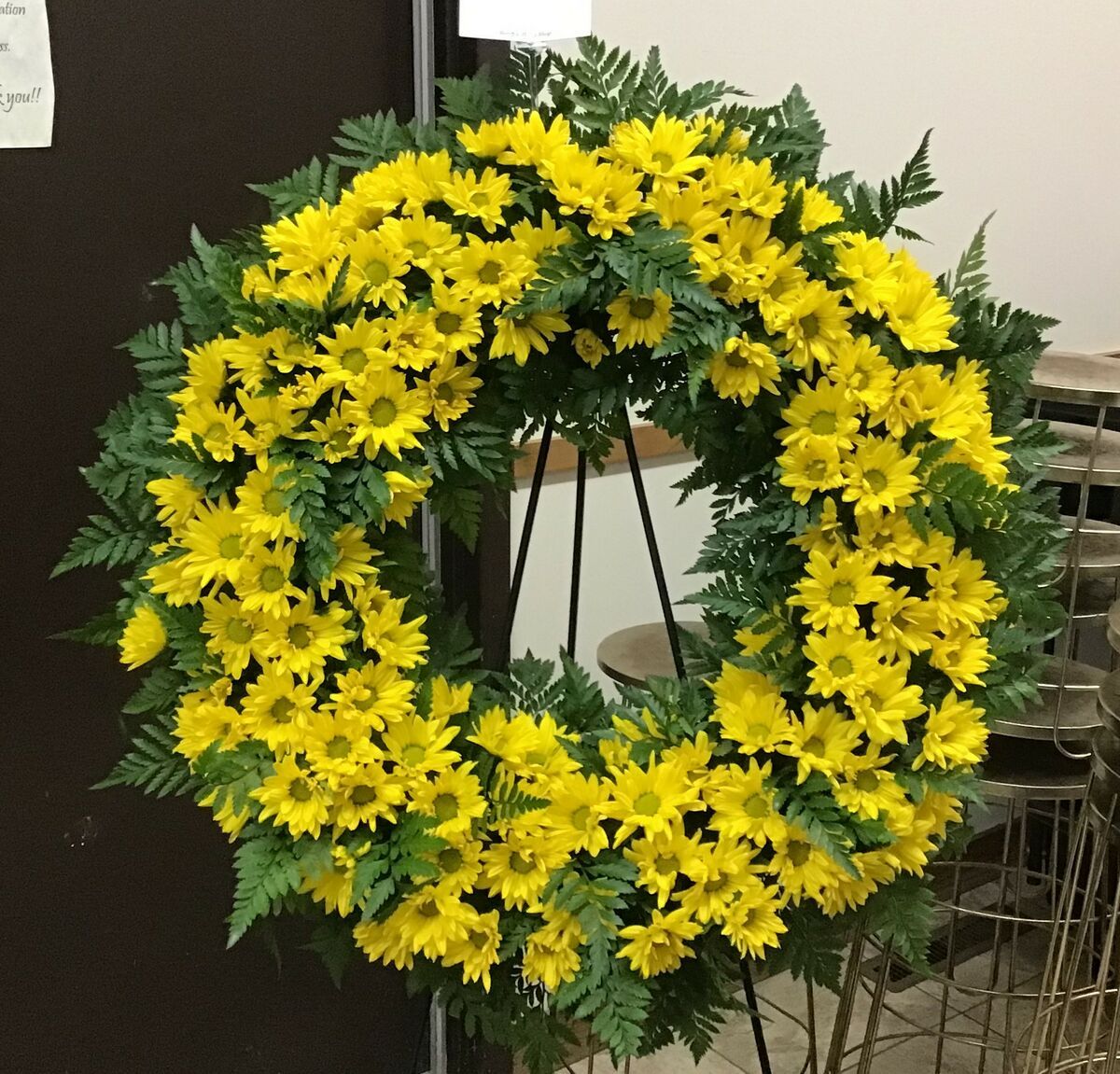 A wreath with yellow flowers and green leaves