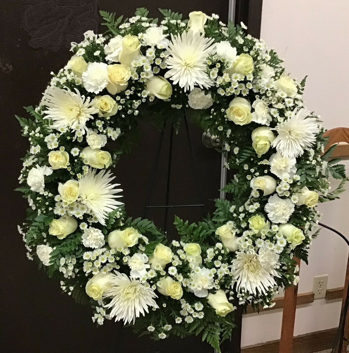 A wreath of white flowers is sitting on a chair