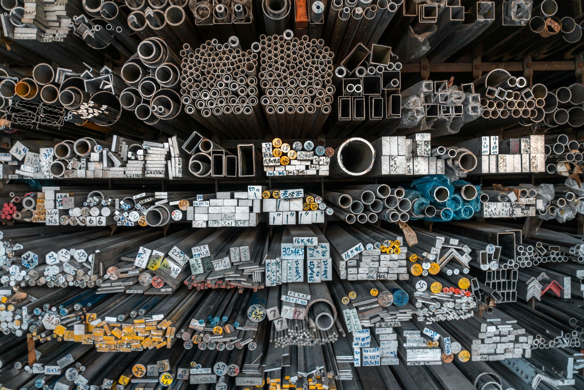 Metal bars and tubes of various shapes and sizes stored on shelves.