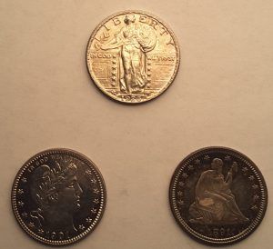 Three coins with one that says liberty on it.