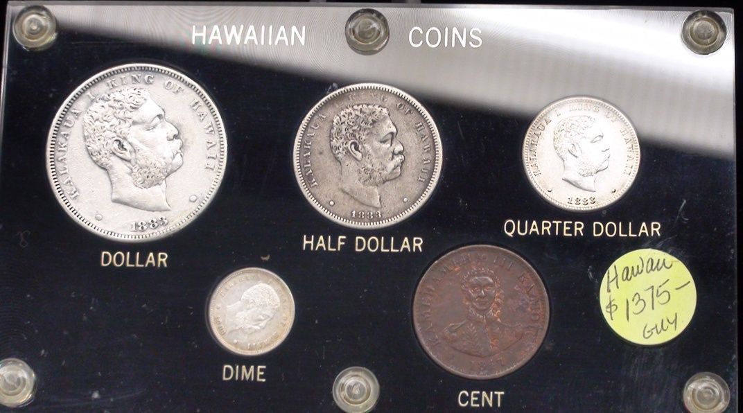 A collection of hawaiian coins including a half dollar quarter dollar dime and cent