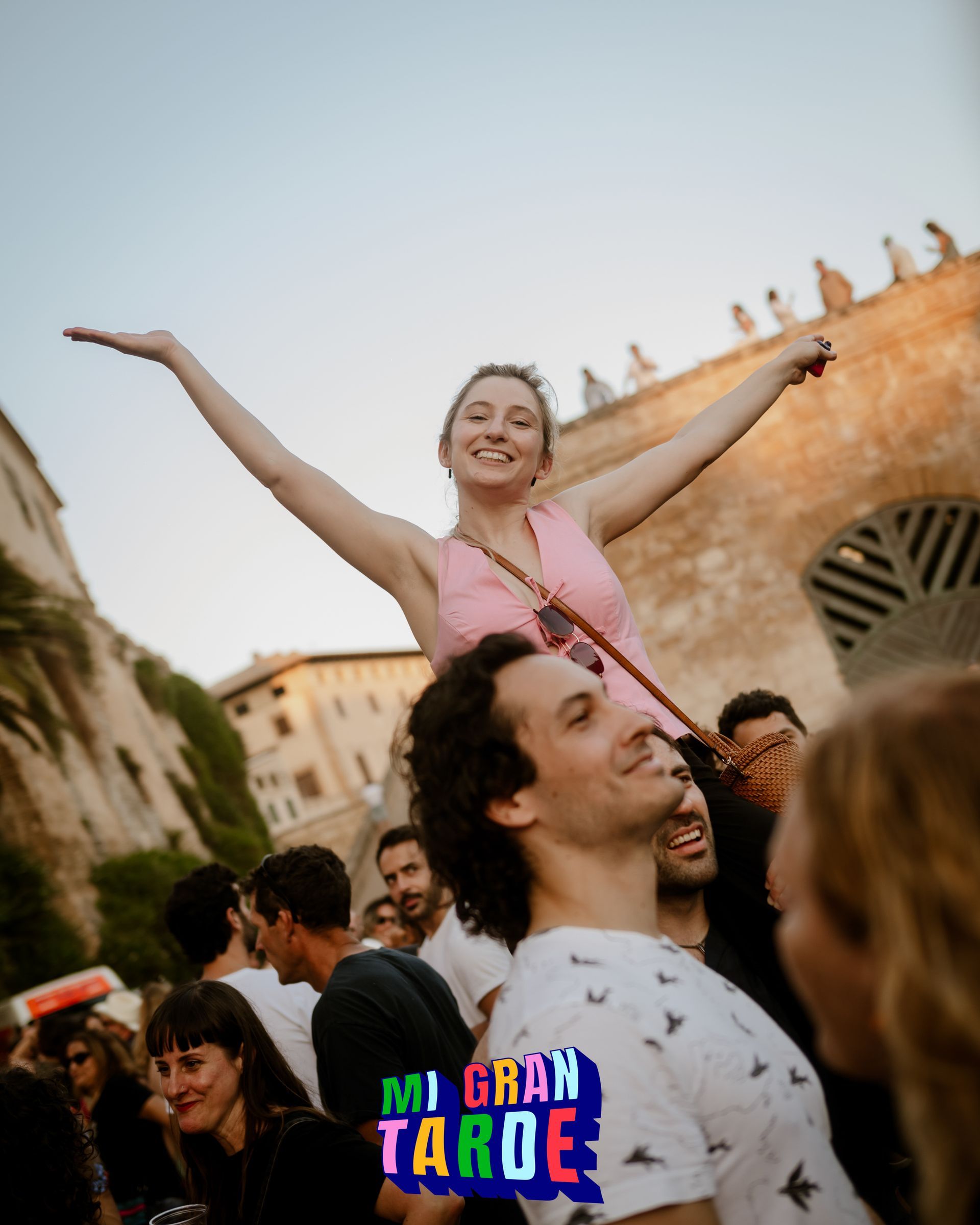 Un hombre lleva a una mujer sobre sus hombros en una fiesta.