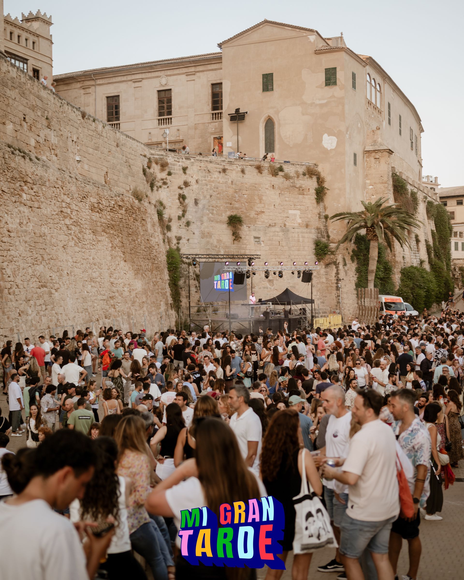 Una multitud de personas se reúne frente a un edificio con un cartel que dice mi gran taroe