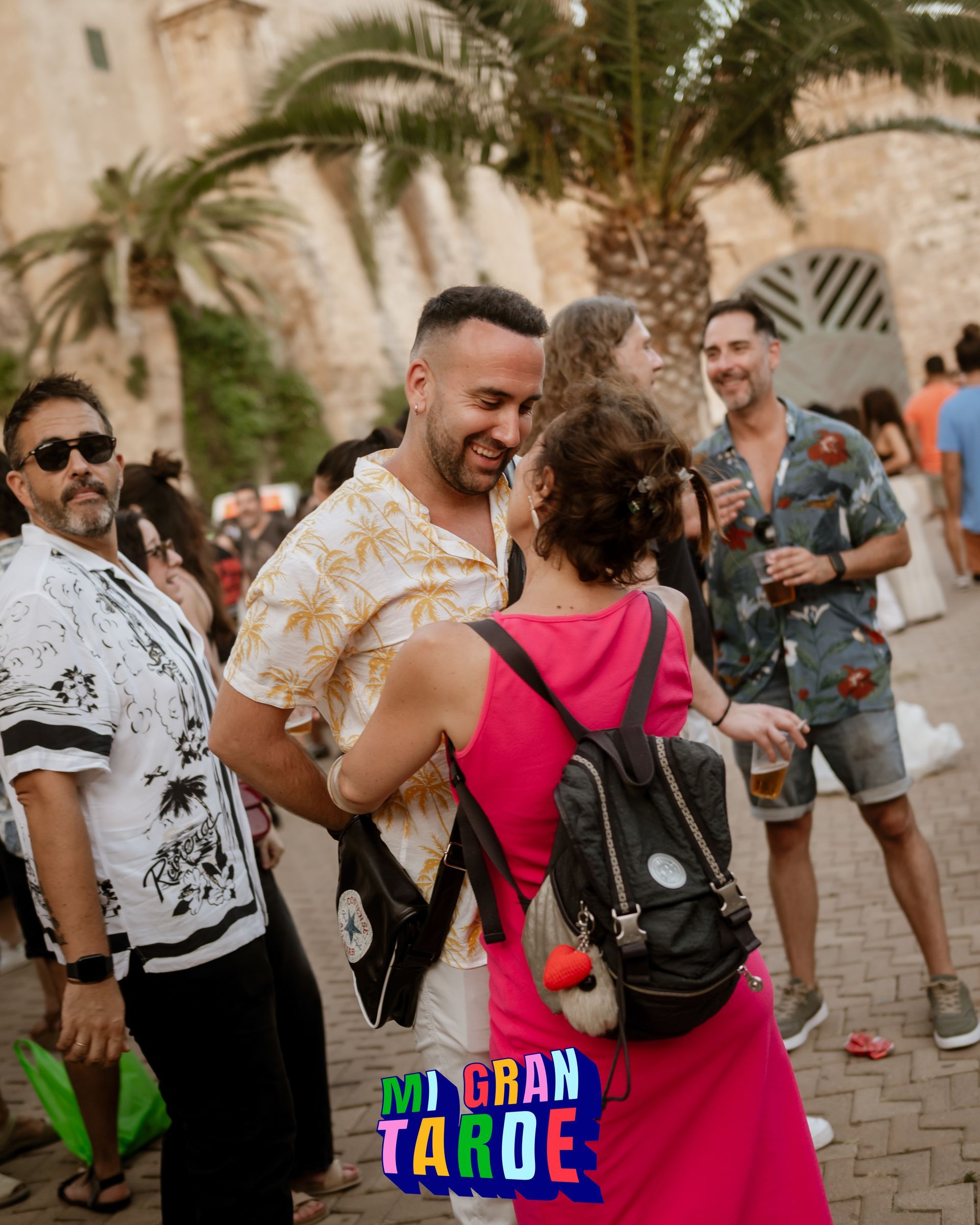 Un grupo de personas está de pie frente a un cartel que dice mi gran tarde