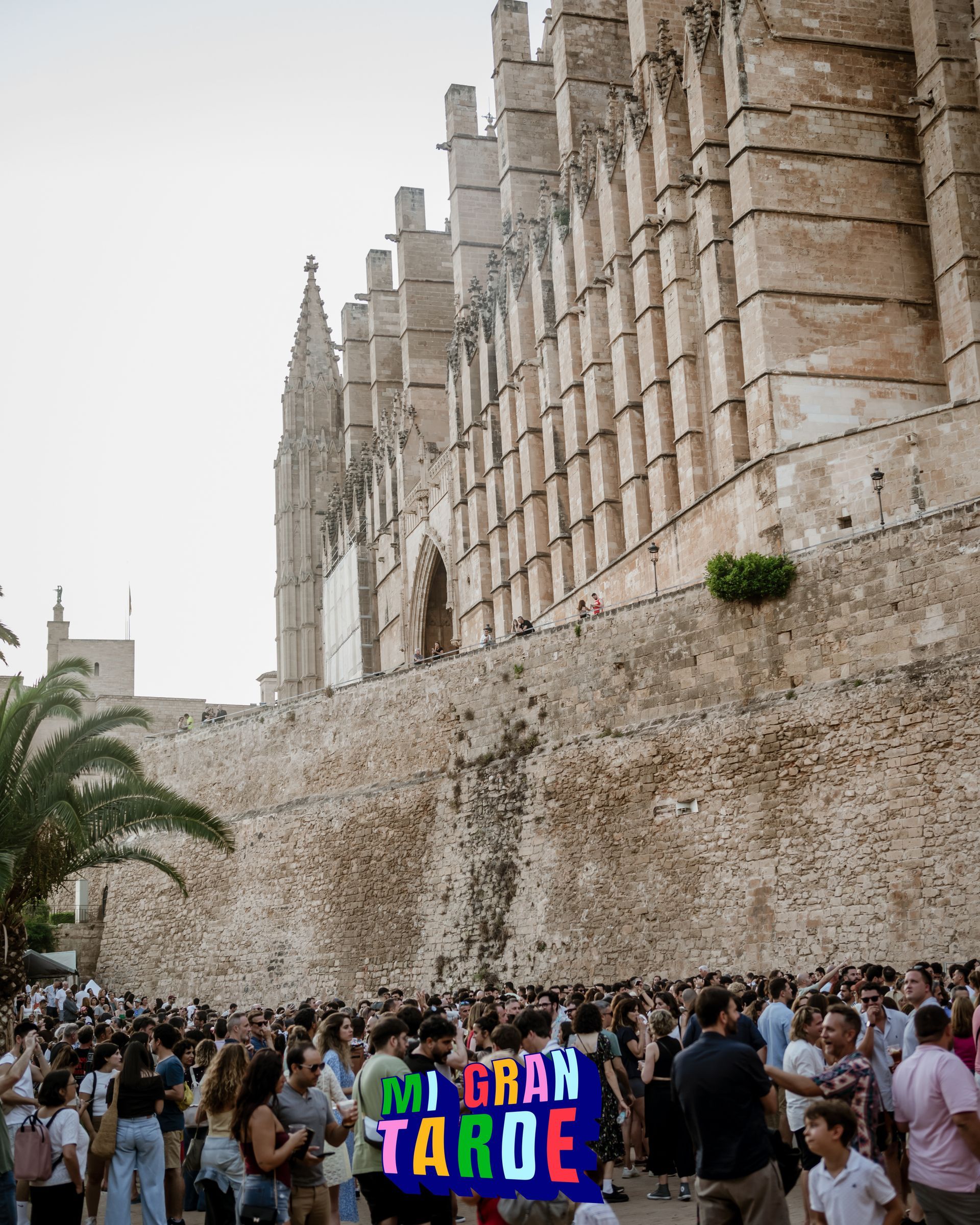 Una multitud de personas está reunida frente a un gran edificio de piedra.