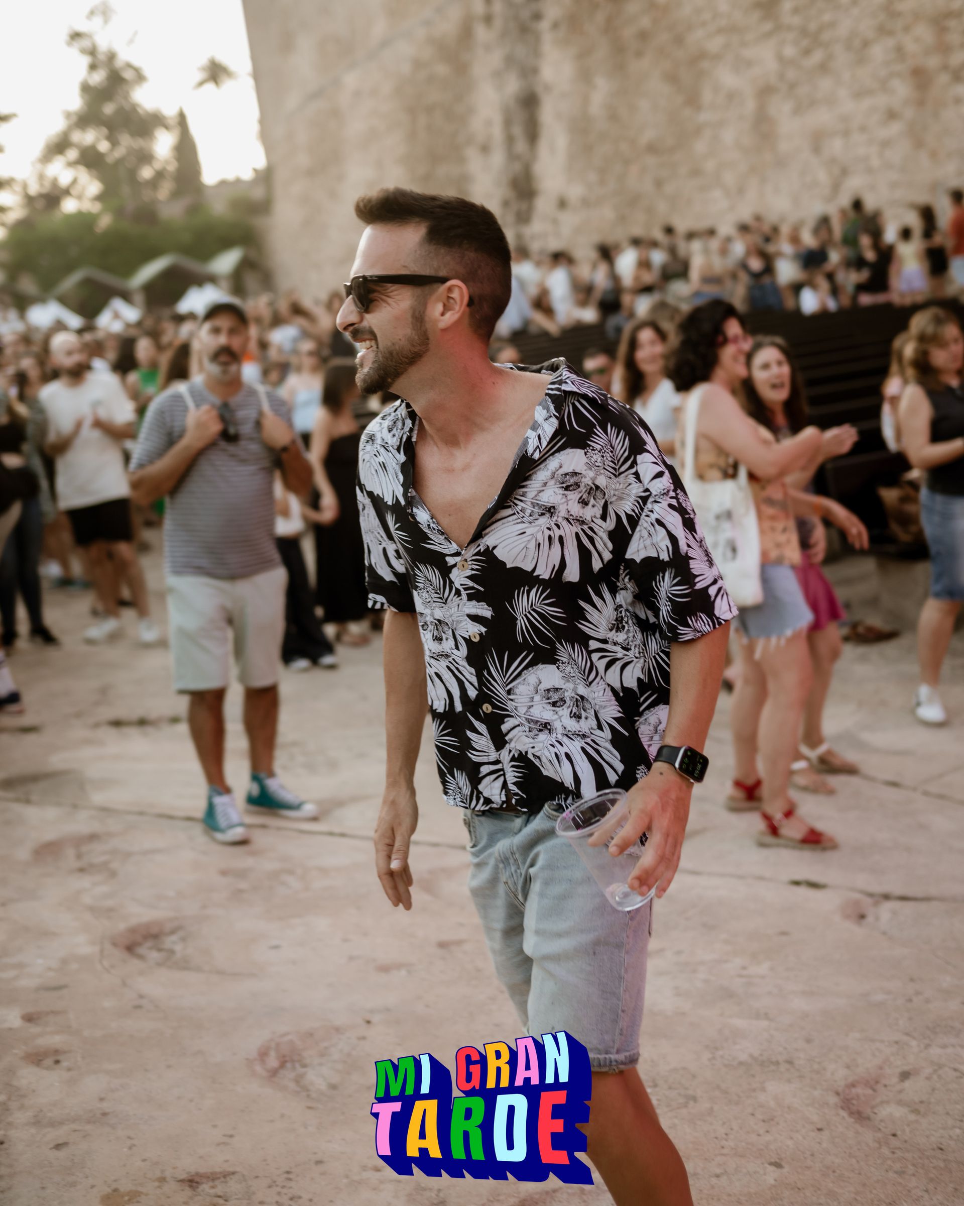 Un hombre está parado frente a una multitud con un cartel que dice gran tarde
