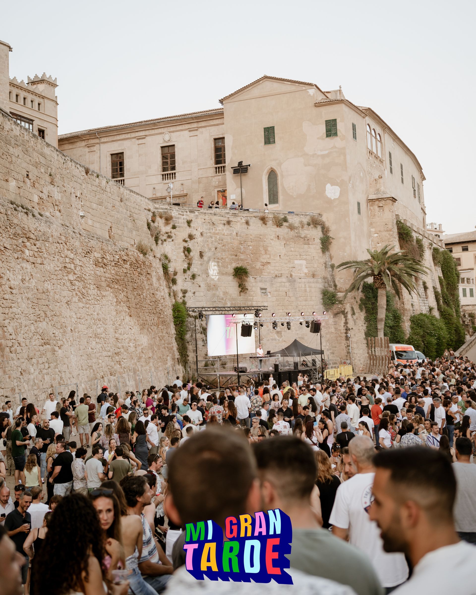 Una multitud de personas se reúne frente a un castillo y un cartel que dice mi gran tarde