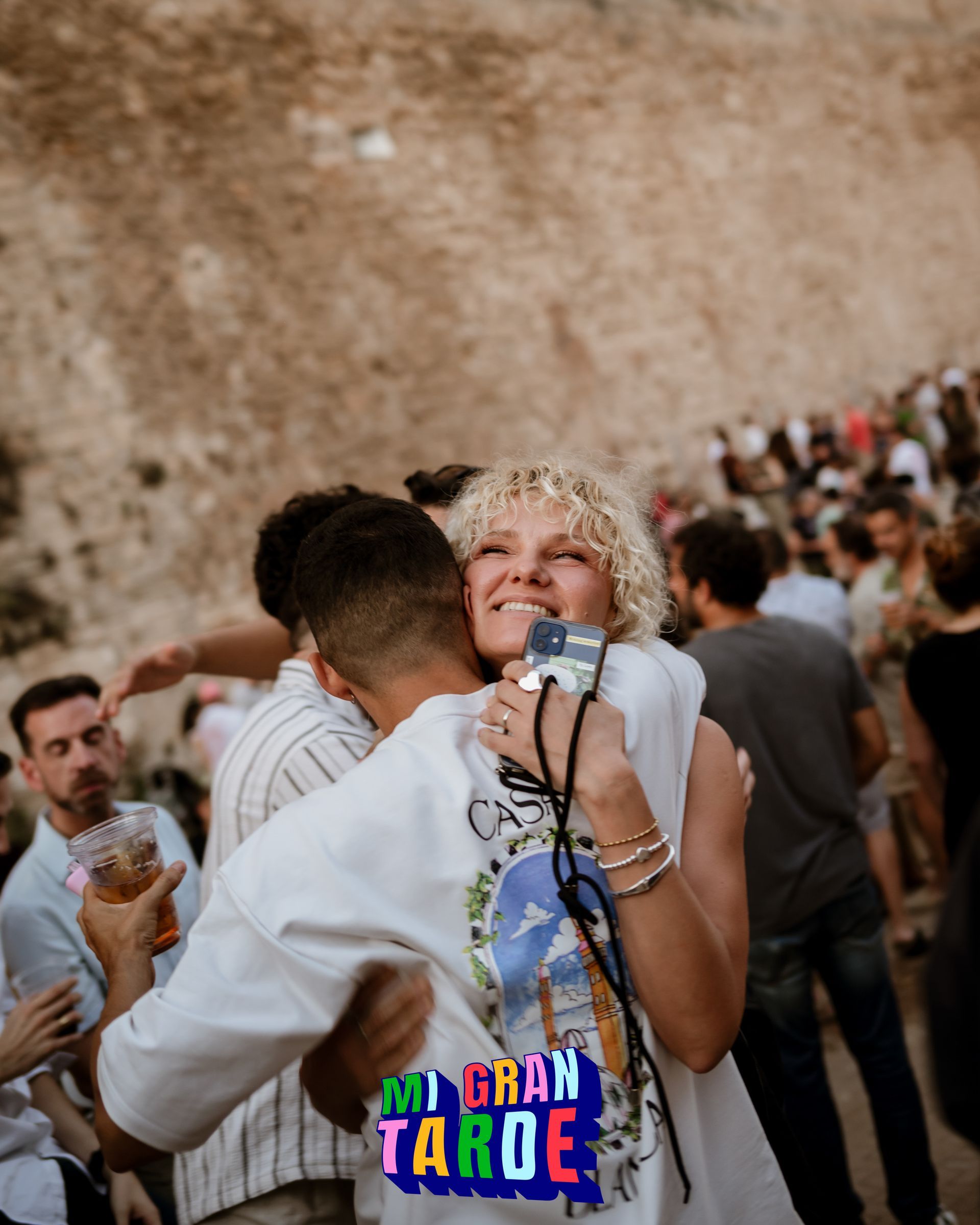 Un hombre abraza a una mujer frente a un cartel que dice mi gran taroe