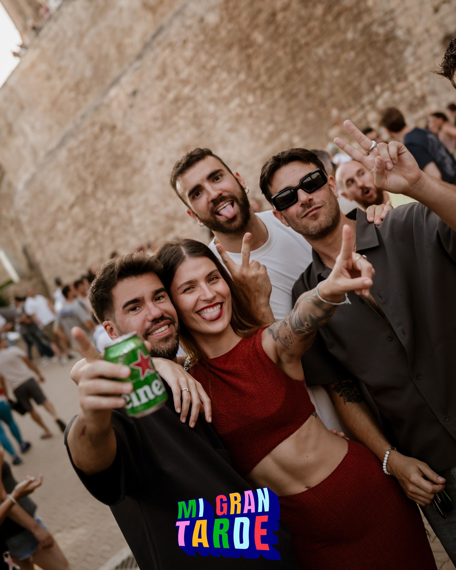 Un grupo de personas posa para una fotografía y una de ellas sostiene una lata de cerveza Heineken.