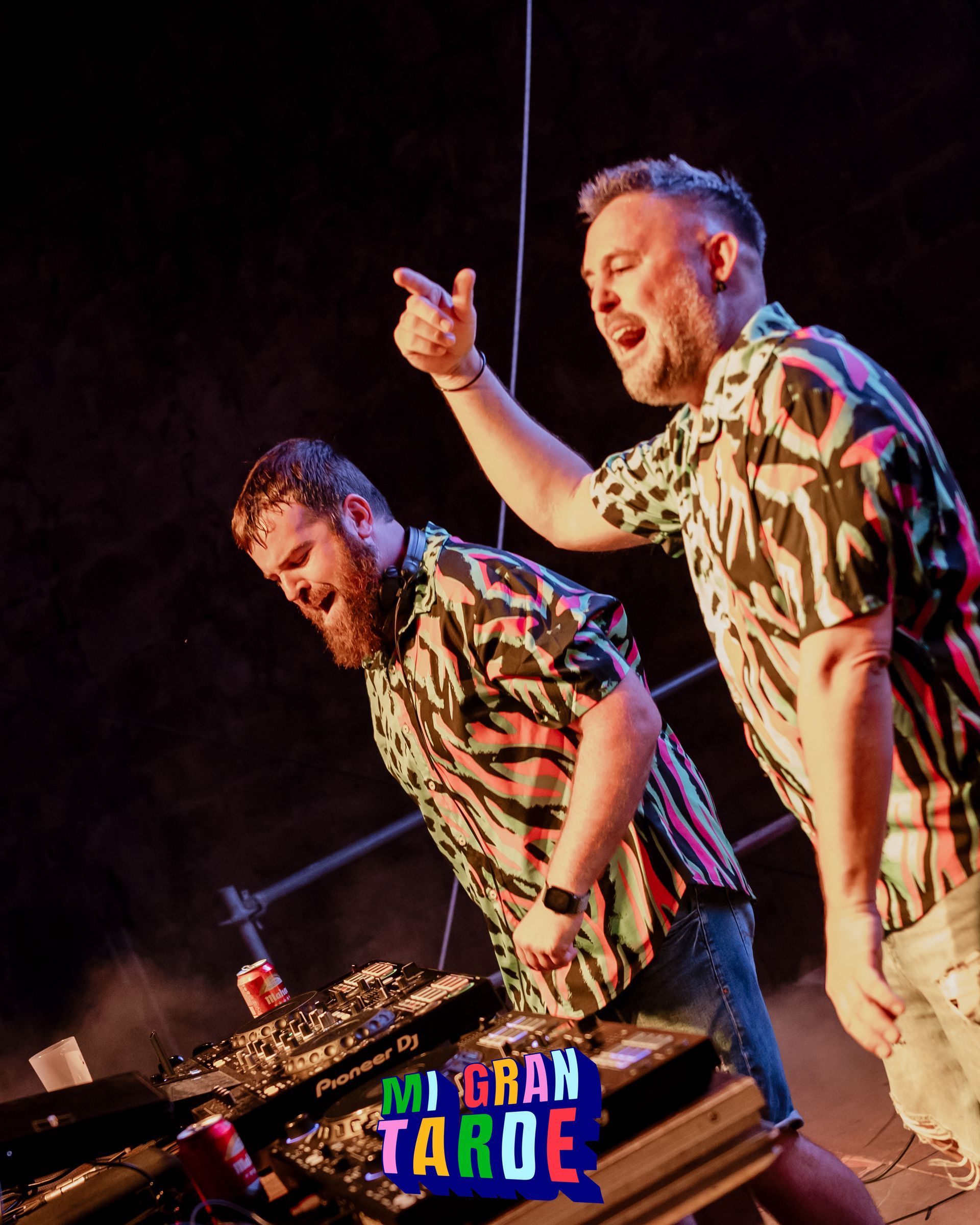Dos hombres están parados frente a un cartel que dice 