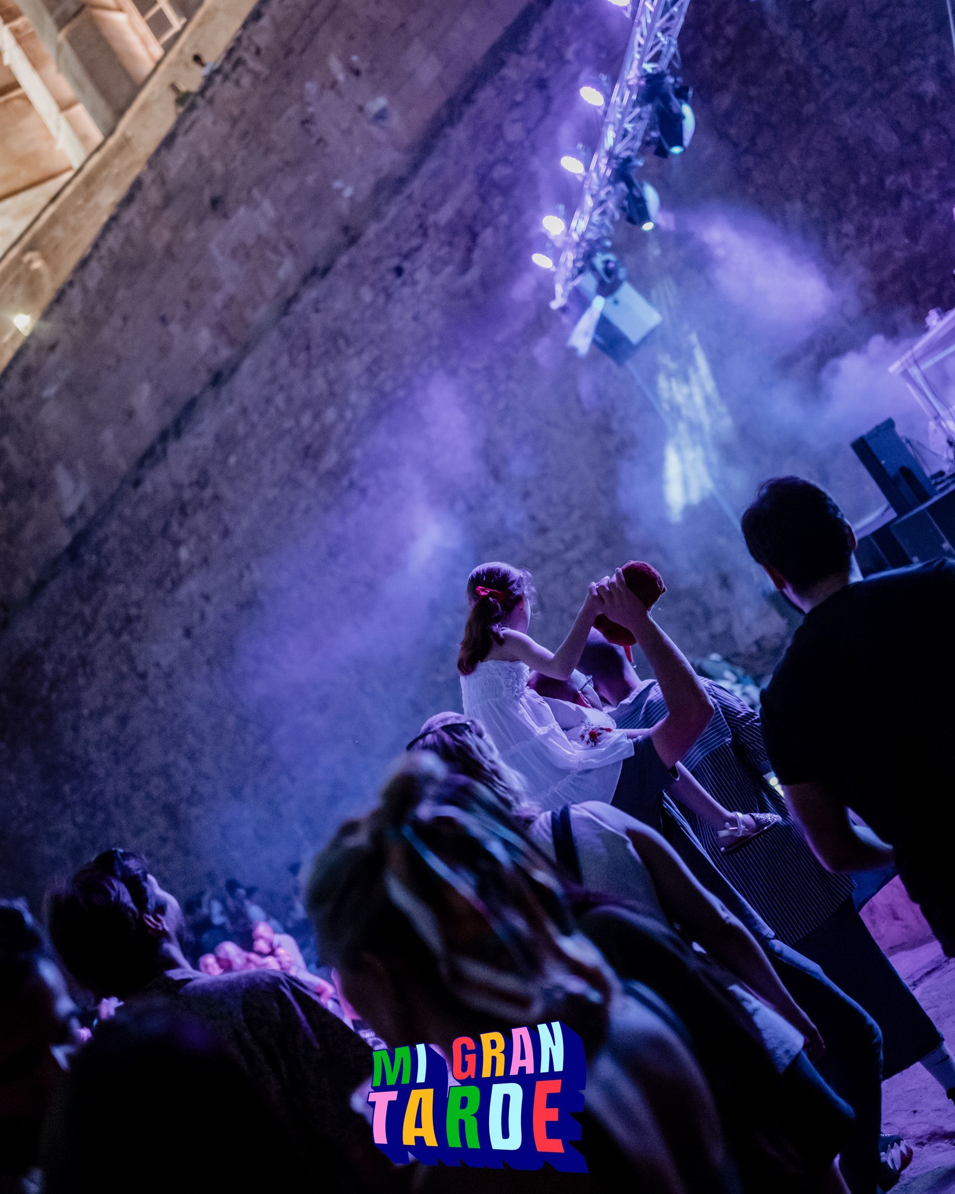 Un grupo de personas baila frente a un cartel que dice mi gran tarde