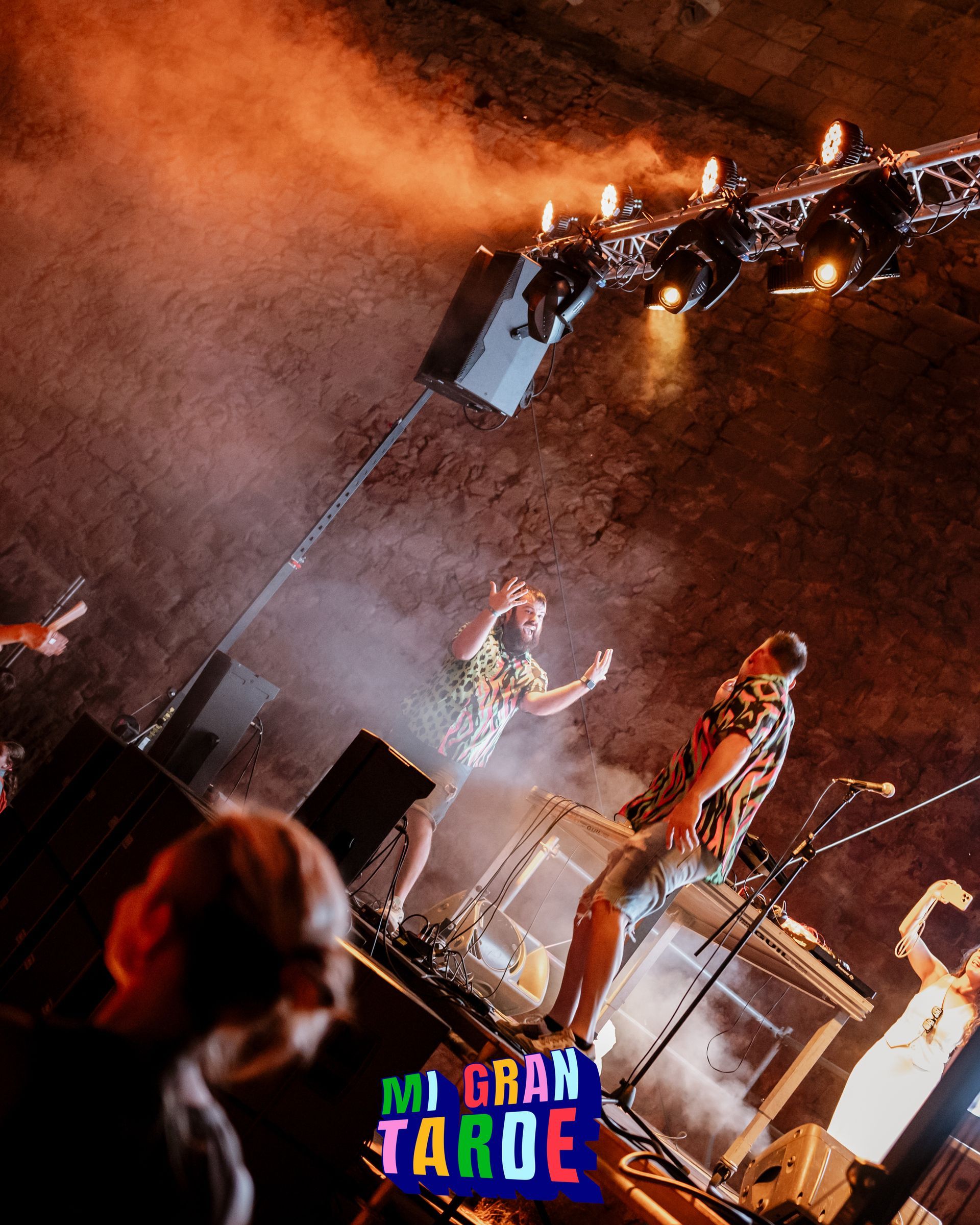 Un grupo de personas está de pie en un escenario frente a un cartel que dice mi gran taroe