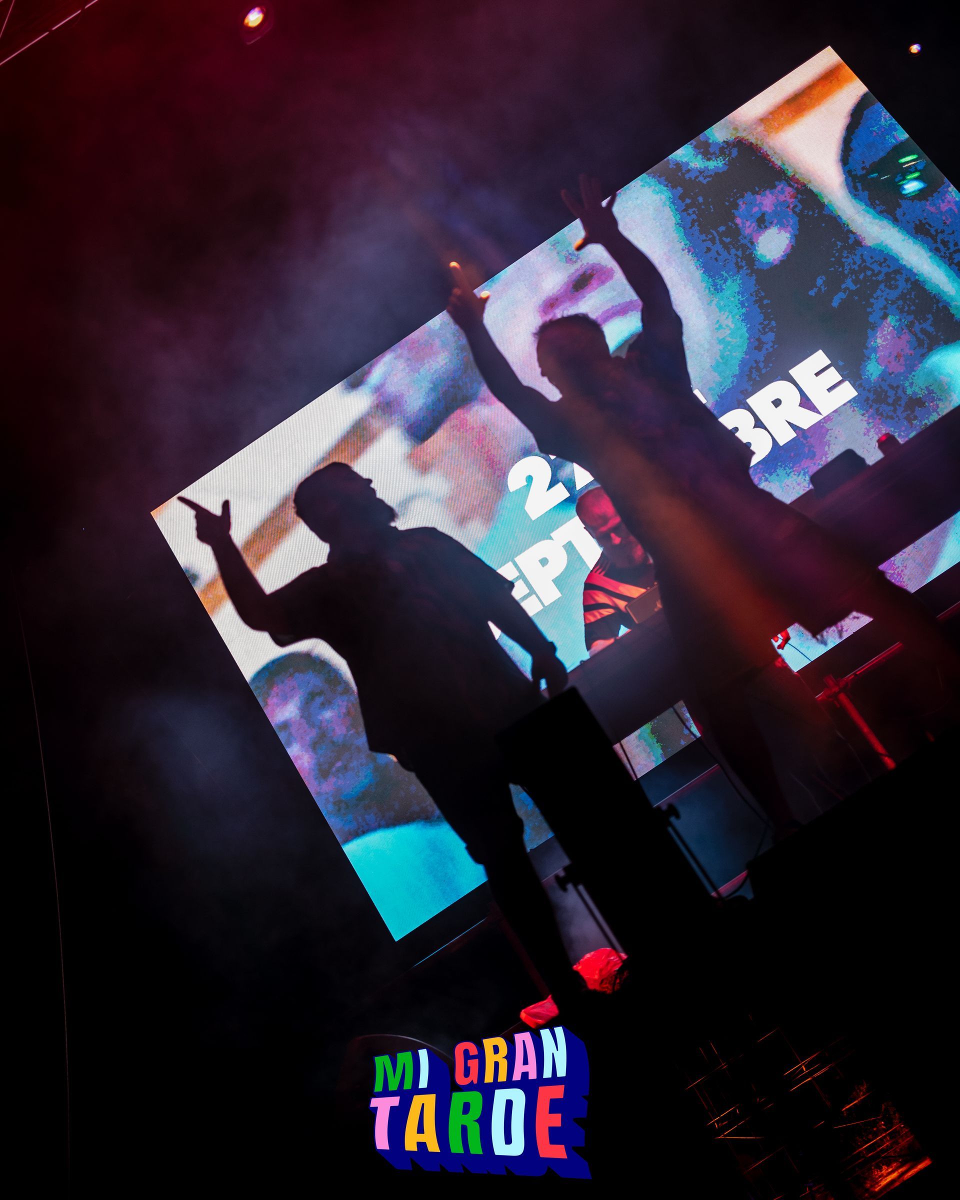 Un hombre está parado frente a una pantalla grande que dice 