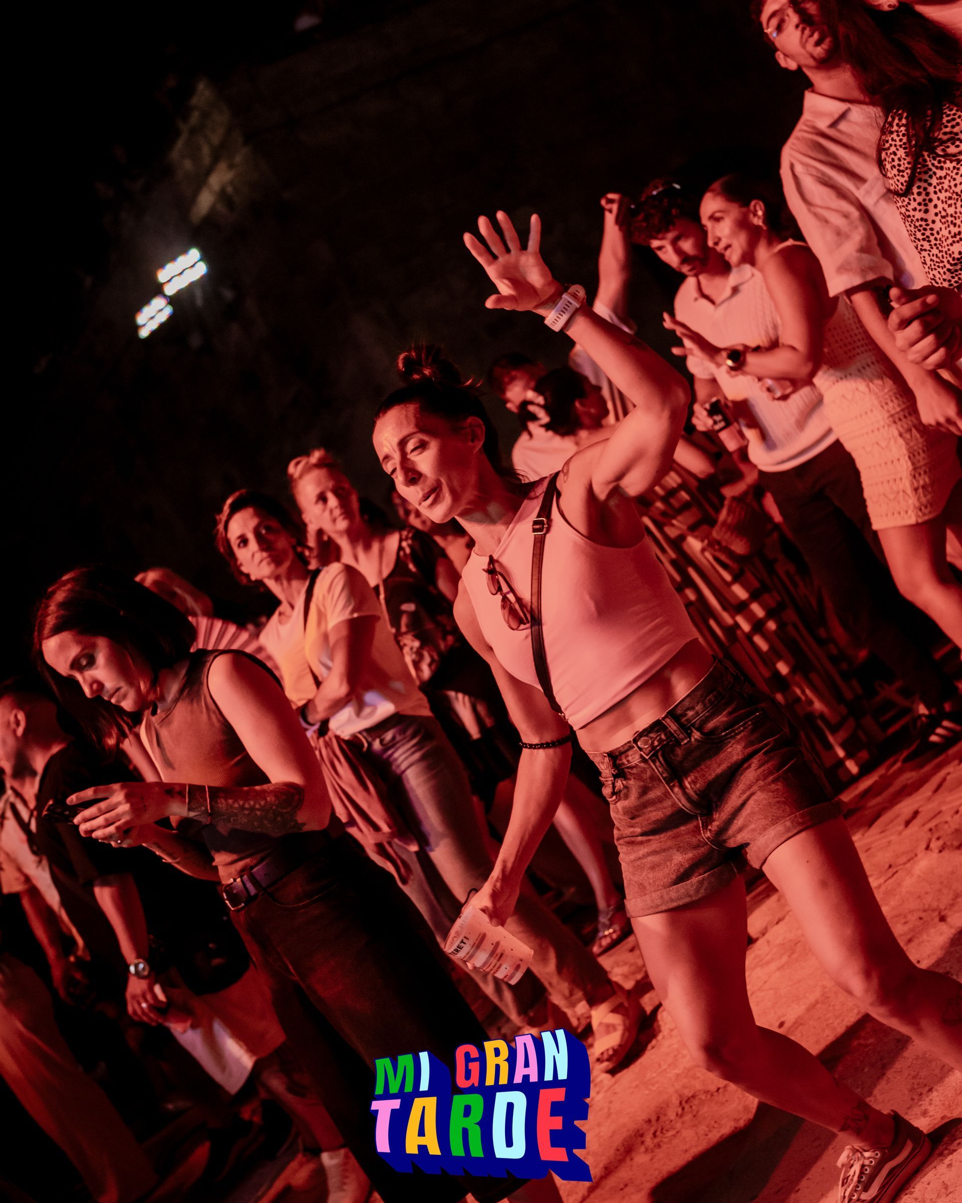 Un grupo de personas baila frente a un cartel que dice mi gran tarde