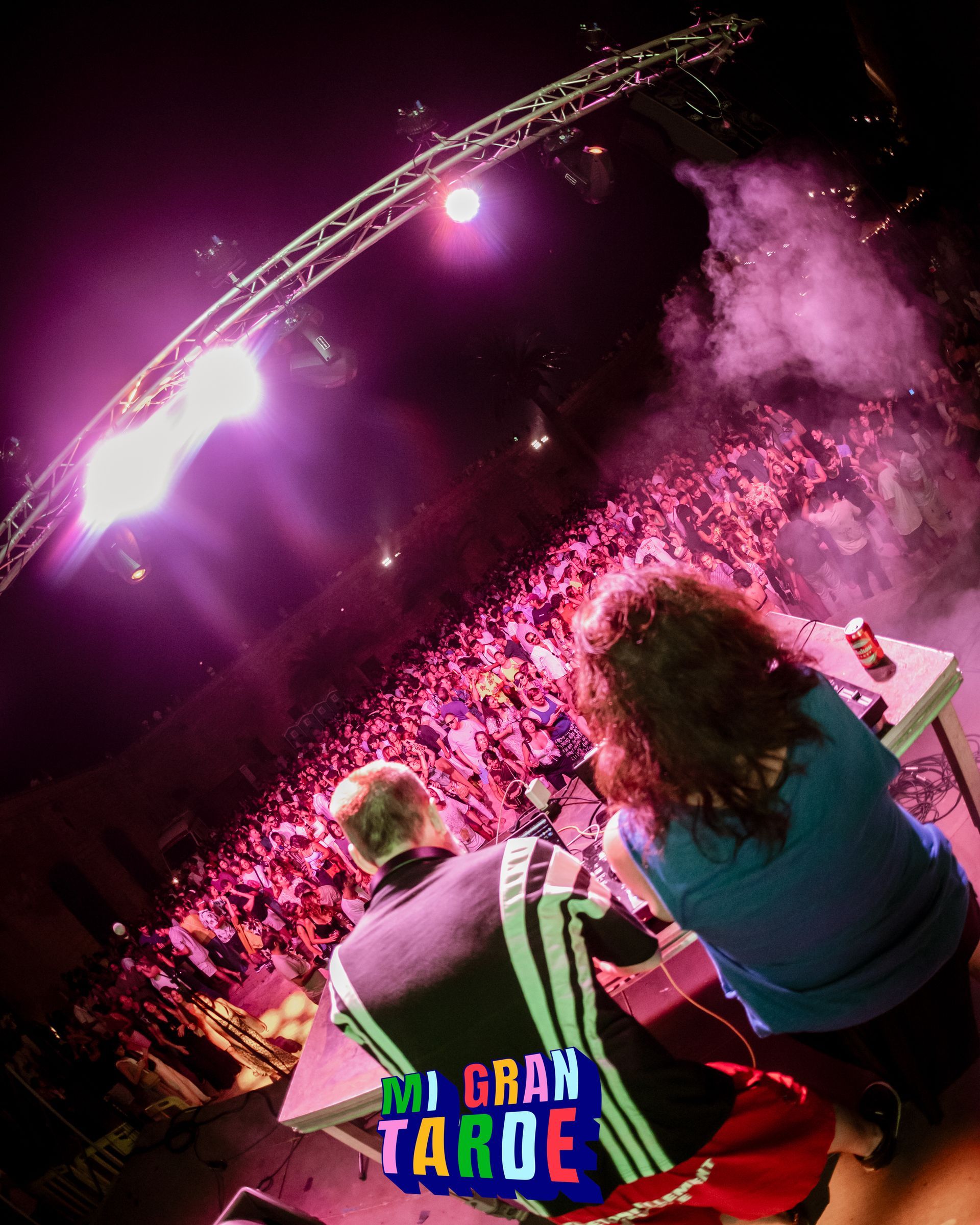 Un hombre y una mujer están sentados frente a una multitud en un concierto de Mi Gran Tarde.