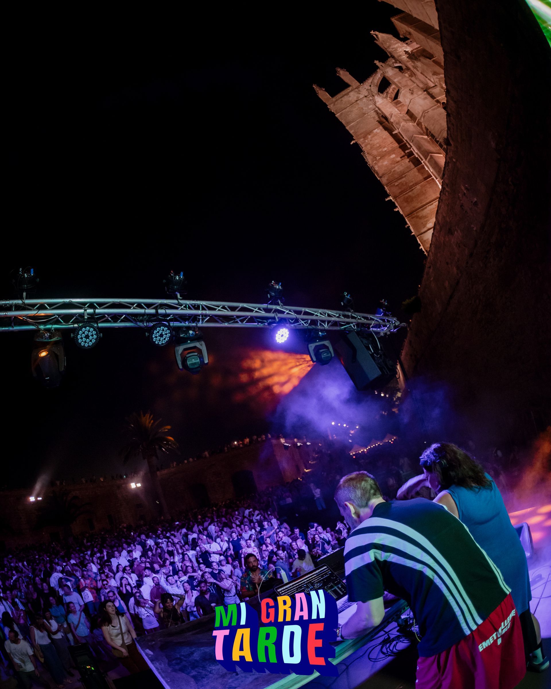 Un grupo de personas de pie frente a un escenario que dice mi gran tarde