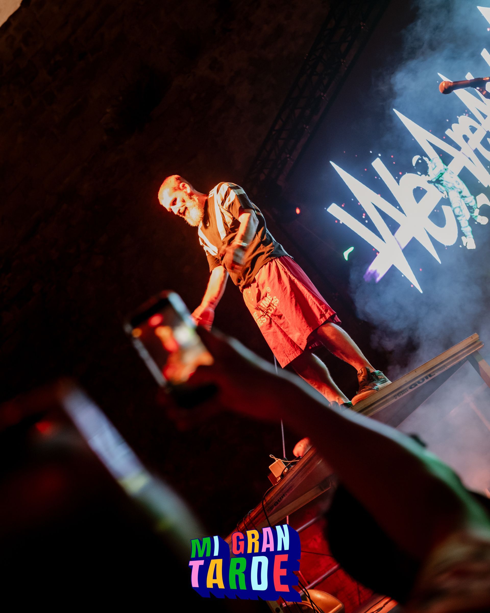 Un hombre está de pie en un escenario frente a un cartel que dice Mi gran tarde.